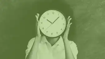 Woman holding clock over her face